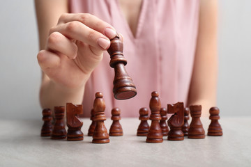 Woman with chess pieces at table. Concept of developing strategy for career growth
