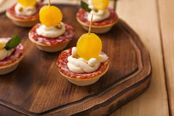 Tasty canapes on wooden board