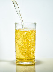 Beer pouring from bottle into glass isolated on white