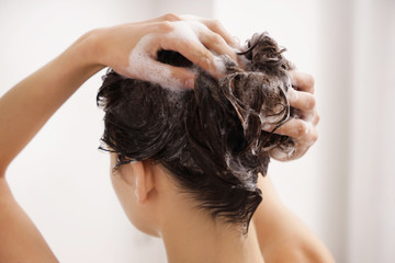 Fototapeta premium Young woman washing hair in bathroom