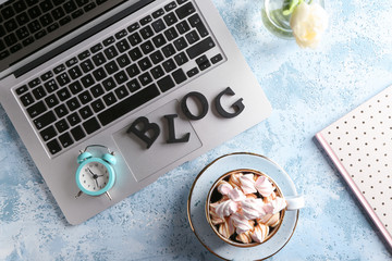 Word BLOG with laptop, cup of coffee and alarm clock on table