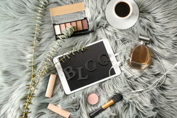 Tablet PC with word BLOG and makeup cosmetics on plaid