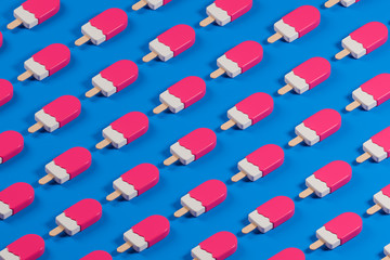 Isometric pattern made of pink glossy lolly ice cream on the blue table.