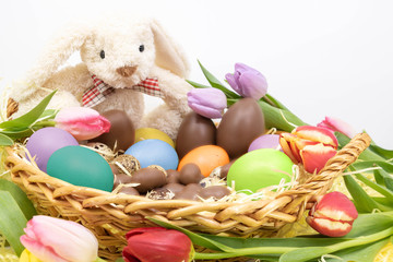 Lapin de Pâques, oeufs peints et oeufs en chocolat avec des tulipes colorées