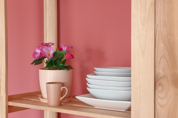 Clean dishes on wooden shelf in kitchen