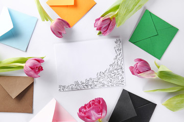 Greeting card with envelopes and tulips on white background