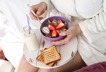 Young woman having breakfast in bed