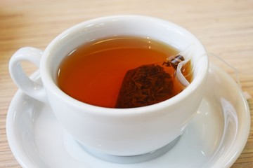 Fragrant black tea in a bag in a white Cup.