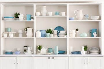 Fototapeta na wymiar Open cupboard with clean dishes in kitchen