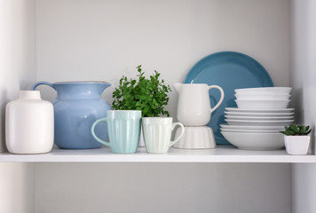 Shelf with clean dishes in kitchen