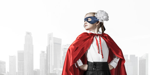 Girl power concept with cute kid guardian against cityscape background