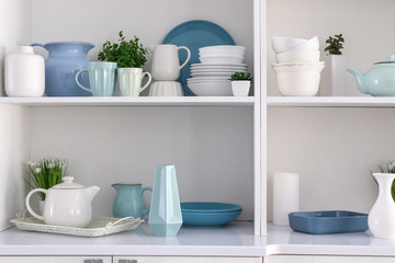 Fototapeta na wymiar Open cupboard with clean dishes in kitchen