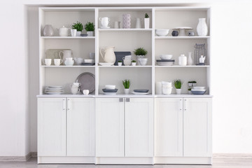 Open cupboard with clean dishes in kitchen