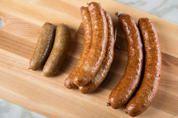 Regionale norddeutsche Grünkohl Kohlwurst Variation aus Bremer, Oldenburger und Ammerländer Pinkel auf  Holzbrett auf Marmor Tisch