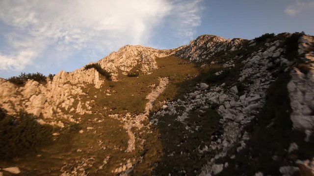 Cinematic fpv drone footage. Bird view of beautiful mountains edge. Sunset rays in the clouds 