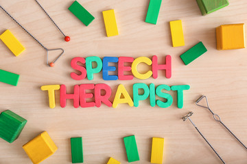 Composition with text SPEECH THERAPIST on wooden background