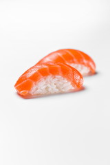 Traditional japanese sushi nigiri with salmon on a white background, vertical shot