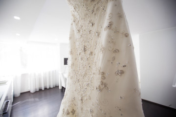 White Wedding dress hanging on a shoulders