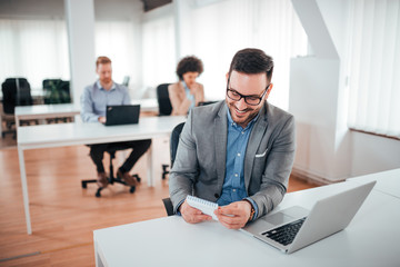 Handsome man doing some paperwork in office.