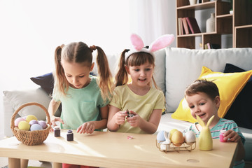 Fototapeta premium Cute little children painting Easter eggs at home