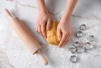 Woman preparing cookie on light table