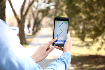 Woman using mobile phone for navigation outdoors