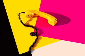 Retro vintage phone handset yellow pink red purple plastic orange disko background old style shadow...