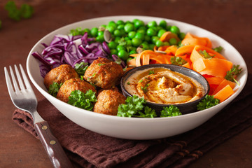 healthy vegan lunch bowl with falafel hummus carrot ribbons cabbage and peas
