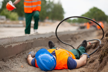 Closeup of injured road construction worker lying on the ground
