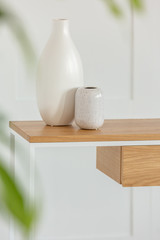 Beige vases on wooden table in living room interior