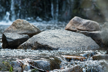 Fototapeta na wymiar Rock in the middle of a flowing stream