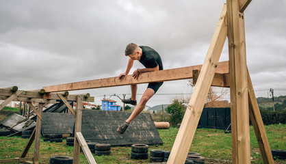Male participant in a obstacle course doing irish table obstacle