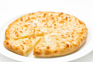 Georgian cuisine khachapuri with cheese freshly baked served on a white plate , close up on a white background