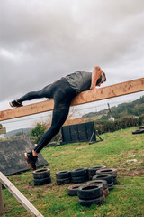 Male participant in a obstacle course doing irish table obstacle