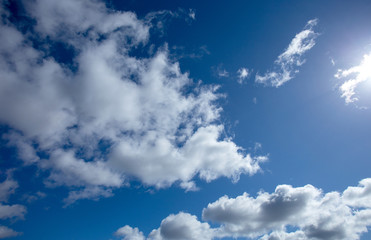 Naklejka na ściany i meble White fluffy clouds in bright blue sky minimal