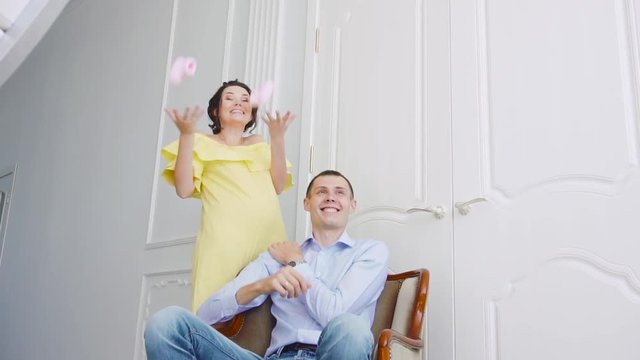 pregnant girl in a yellow dress with her husband in the interior