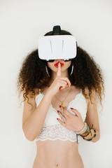 Sexy young woman using virtual reality headset for cybersex or watching porn. Secret online relationship concept.
