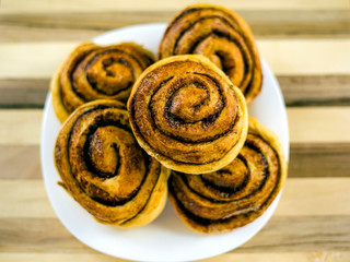 homemade cinnamon buns with caramelized sugar tasty and beautiful, sliced ​​and baked in the oven rolls and black coffee