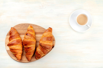 A high key overhead photo of a breakfast with croissants and coffee, with a place for text