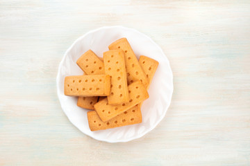 A photo of Scottish shortbread butter cookies, shot from the top on a white wooden background with a place for text