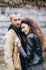 Tender romantic cheerful happy couple walking outdoors hugging and kissing each other outdoors in park. Relationships, love, hipster couple concept