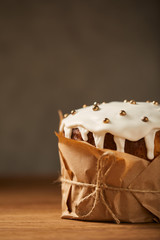 traditional easter cake decorated with frosting and sprinkles on wooden table with copy space
