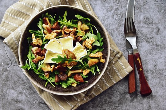 Mushrooms, dried figs and walnut salad with brie cheese. Top view salad isolated