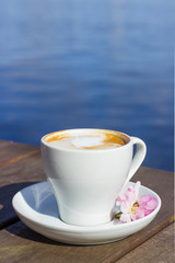 Cup of cappuccino at the wooden table with a view to the lake, Hamburg