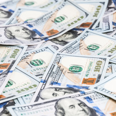 Background from dollars. Notes of one hundred American dollars are scattered across the background.