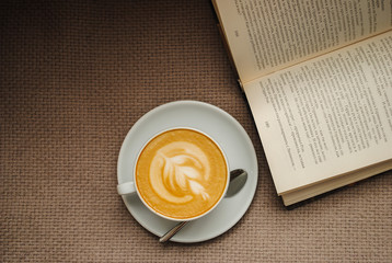 A cup of hot coffee and a book