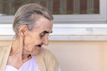 Very old senior woman sitting in the balcony on a summer day