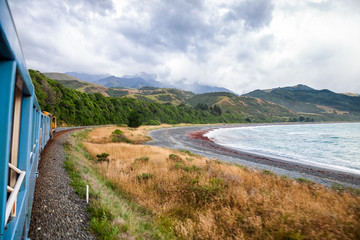 Scenic coastal railway journey along Pacific ocean coast in New Zealand
