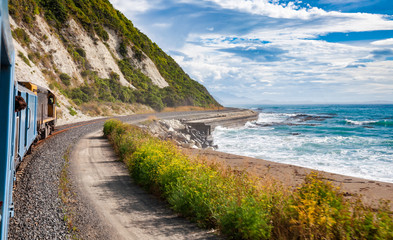 Scenic coastal railway journey along Pacific ocean coast in New Zealand