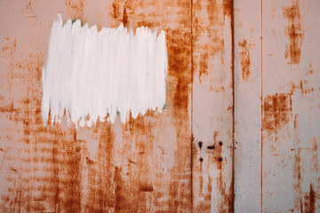 Rust metal surface. Partly rusty background. Rough oxide plate close-up. White painted spot. Copy space, mock up. Hard decay texture. Oxidation of steel. Partially rusted metal panel. Peeling paint.